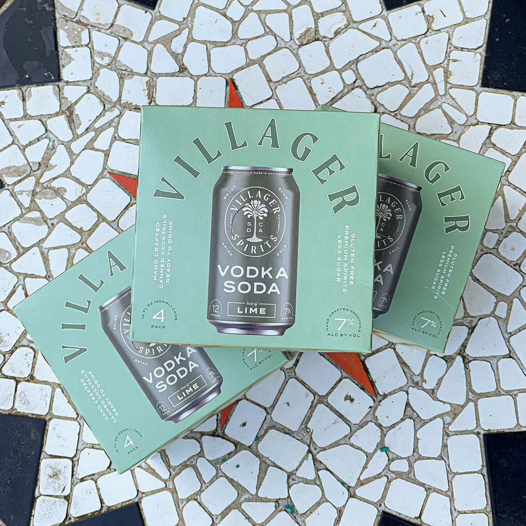 Three Villager Spirits Vodka Soda Twist of Lime 8 packs stacked on a tile mosaic table top.